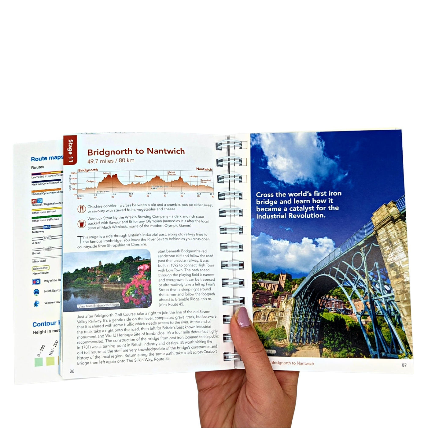 Hand holding guidebook open, showing a title page with a full colour blue sky photo and a route profile.